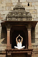 Man in yoga posture sitting in ancient monument - Alex Mares-Manton