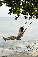 Boy swinging near ocean - Alex Mares-Manton