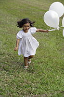 Child running with white balloons - Alex Mares-Manton