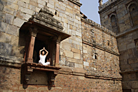 Woman in yoga posture, sitting in ancient monument - Alex Mares-Manton