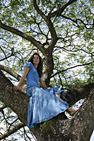 Teen girl sitting in tree - Nugene Chiang