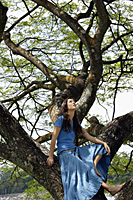 Teen girl sitting in tree - Nugene Chiang
