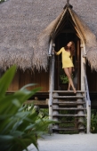 woman standing in doorway of tropical home - Alex Mares-Manton