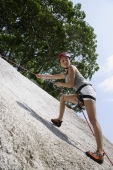 woman rock climbing or repelling - Nugene Chiang