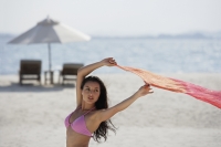 woman on beach holding pink sarong - Alex Mares-Manton