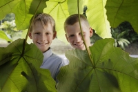 two boys standing behind leaves - Alex Mares-Manton