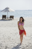 woman on beach wearing pink bikini and sarong - Alex Mares-Manton
