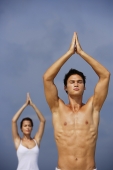 couple doing yoga on the beach - Alex Mares-Manton