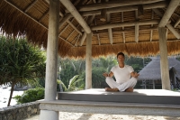 young man doing yoga in outdoor sala - Alex Mares-Manton