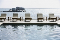 row of poolside lounge chairs - Alex Mares-Manton