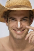 young man wearing hat with sunblock on nose - Alex Mares-Manton
