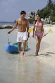couple walking along beach with kayak - Alex Mares-Manton