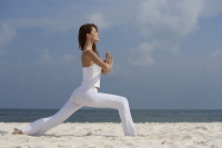Young woman doing yoga on beach - Alex Mares-Manton