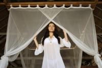 girl on bed under netting - Alex Mares-Manton