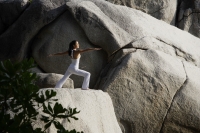 woman doing yoga on rock - Nugene Chiang