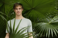 portrait of young man under tropical tree - Alex Mares-Manton