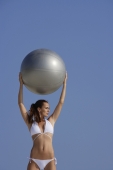 woman in white bikini holding large gray ball - Alex Mares-Manton
