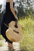 woman walking on path with guitar - Alex Mares-Manton