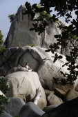 woman doing yoga on rocks - Nugene Chiang