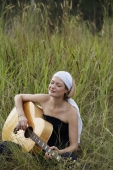young woman playing guitar in field - Alex Mares-Manton