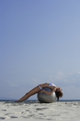woman in bikini lying on giant ball on beach - Alex Mares-Manton