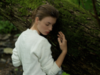 Young woman leaning against tree - Alex Hajdu