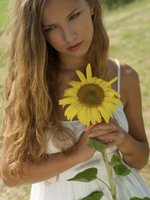 Young woman holding sunflower - Alex Hajdu