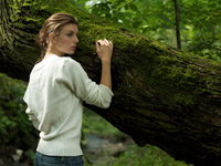 Young woman leaning against tree - Alex Hajdu