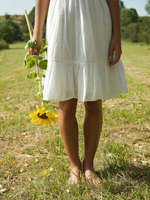 Lower body of young woman, holding sunflower - Alex Hajdu