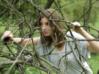 Young woman looking through branches - Alex Hajdu