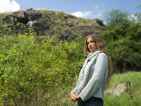 Young woman standing on hillside - Alex Hajdu
