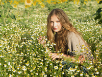 Young woman sitting in field of flowers - Alex Hajdu