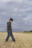 Profile of young man walking in wheat field - Alex Mares-Manton