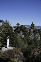 young woman doing yoga on top of mountain - Alex Mares-Manton