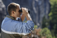 Profile of young man looking through binoculars - Alex Mares-Manton