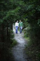 Young couple walking on forest path - Alex Mares-Manton