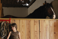 boy in stable next to horse - Alex Mares-Manton