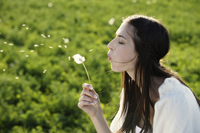 Young woman blowing dandelion - Alex Mares-Manton