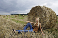 Young woman leaning against haystack - Alex Mares-Manton