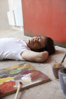 artist on ground with paints - Dennison Bertrand