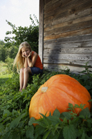 girl sitting by a growing pumpkin - Alex Mares-Manton