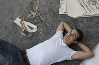 artist lying on studio floor - Dennison Bertrand