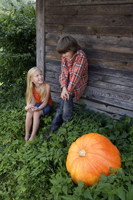 boy and girl next to pumpkin - Alex Mares-Manton