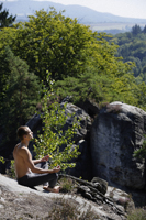 Young man meditating on mountain side - Alex Mares-Manton