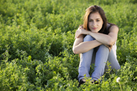young woman sitting in field - Alex Mares-Manton