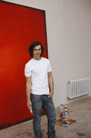 artist working on big red painting - Dennison Bertrand