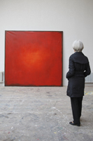 woman standing in front of red painting - Dennison Bertrand