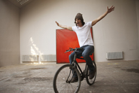young man riding bike in studio - Dennison Bertrand