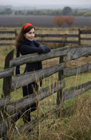 Young woman leaning on country fence - Alex Mares-Manton