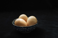 Three brown eggs in blue patterned bowl - Ellery Chua